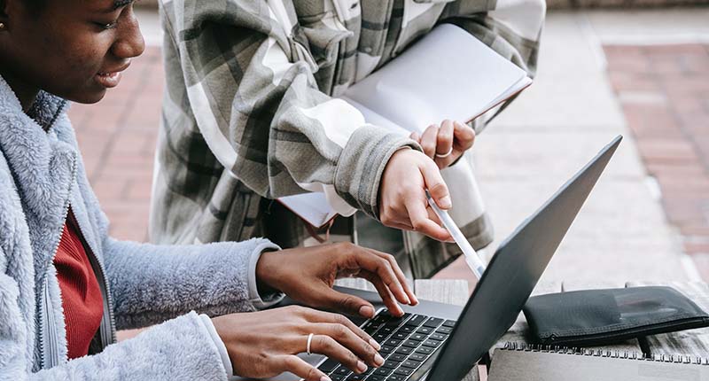 Student being tutored for writing on a laptop